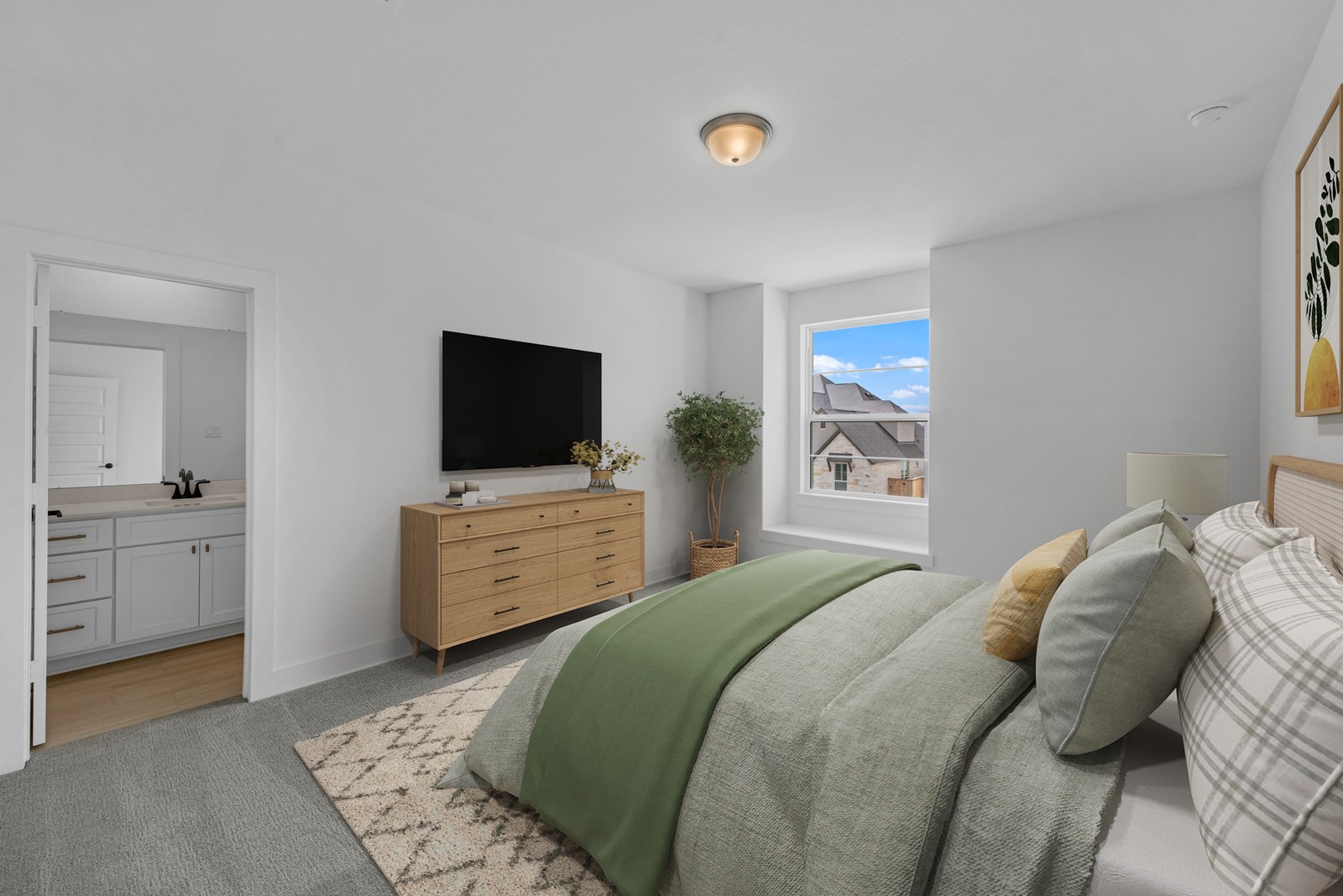 Virtually staged bedroom with a green quilt, wood dresser and wall-mounted TV